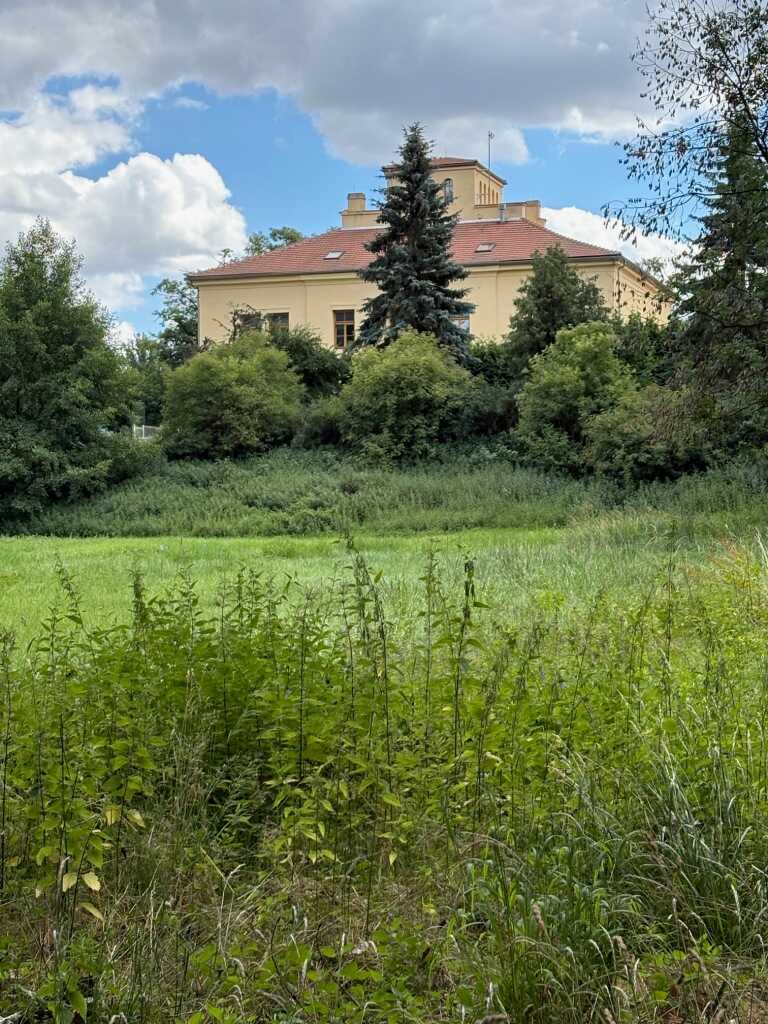 Pohled na budovu č.p. 55, dříve "Vilu Nebeský" z cesty od pramenů směrem k rybníku a zámečku.